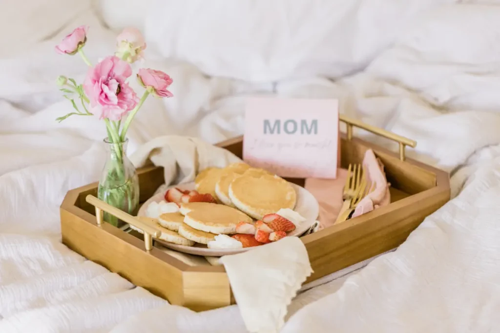 Family celebrating Mother's Day with brunch at home, mother receiving gifts from children.